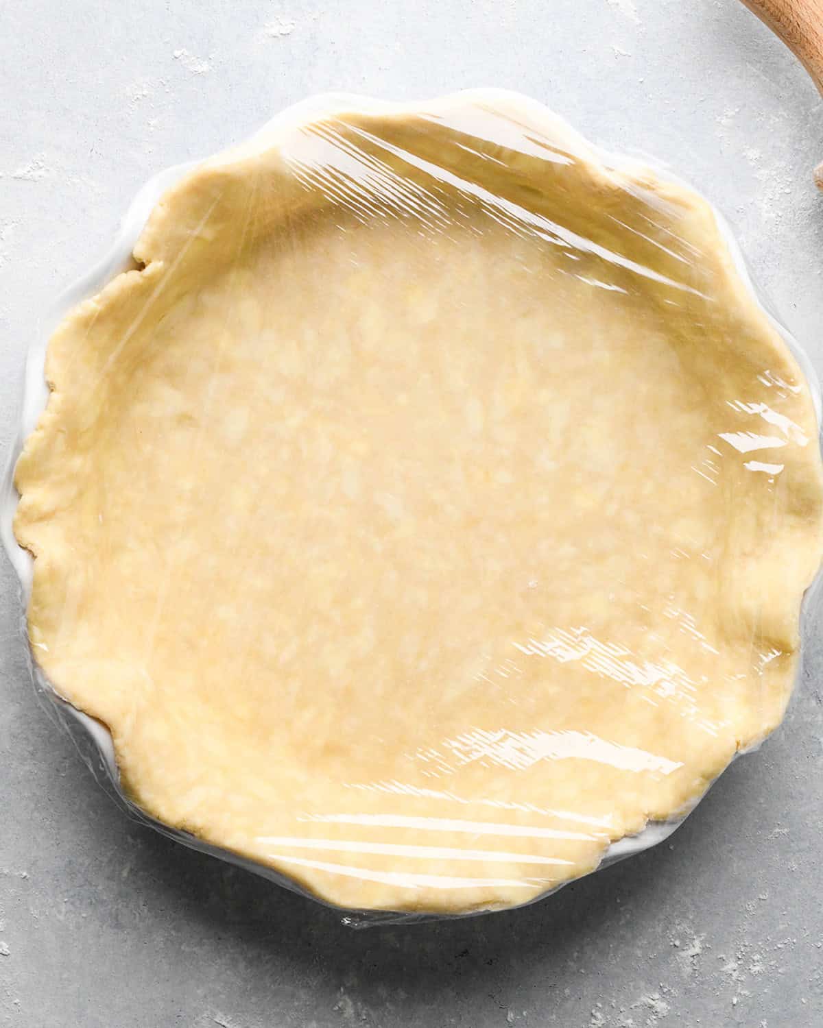 How to Make a Lattice Pie Crust - bottom crust in the pie dish covered with plastic wrap to chill