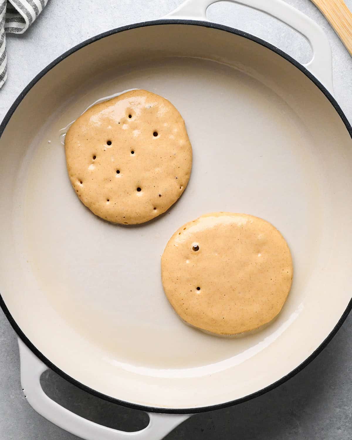 oat flour pancakes cooking on the first side and bubbling