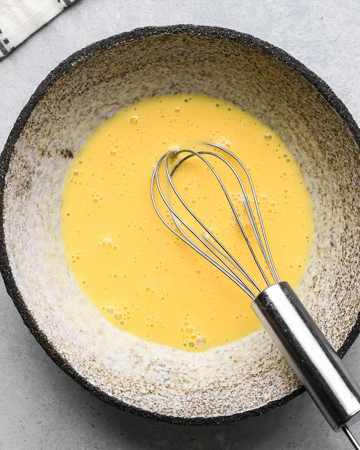 how to make pear pie - egg wash in a bowl with a whisk