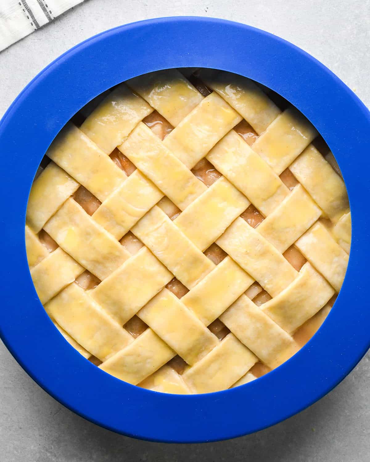 pear pie with lattice crust and pie crust shield before baking