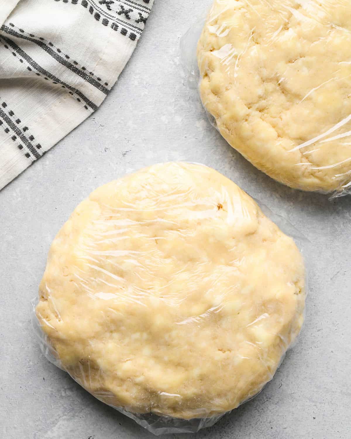 how to make a pear pie crust - two pie dough discs wrapped in plastic wrap