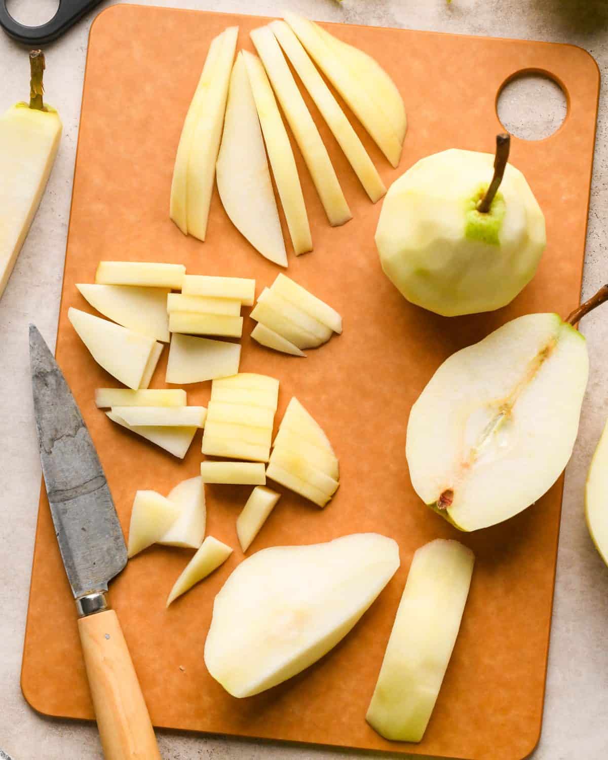peeled pears being cut on a cutting board