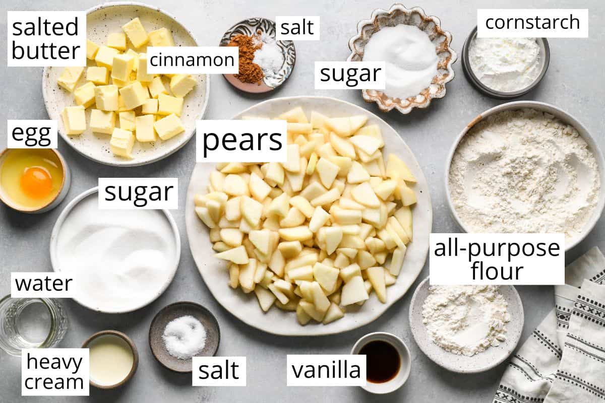 overhead photo of the labeled ingredients in this Pear Pie recipe like pears, flour, sugar,  egg, butter, vanilla and more