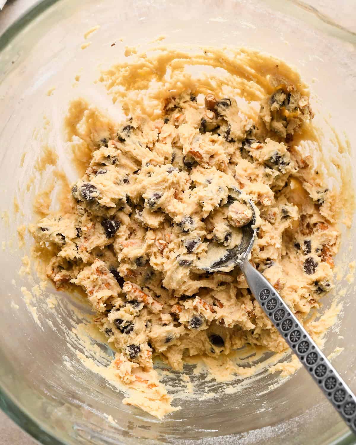 chocolate chip pretzel cookies dough mixed with a spoon in it