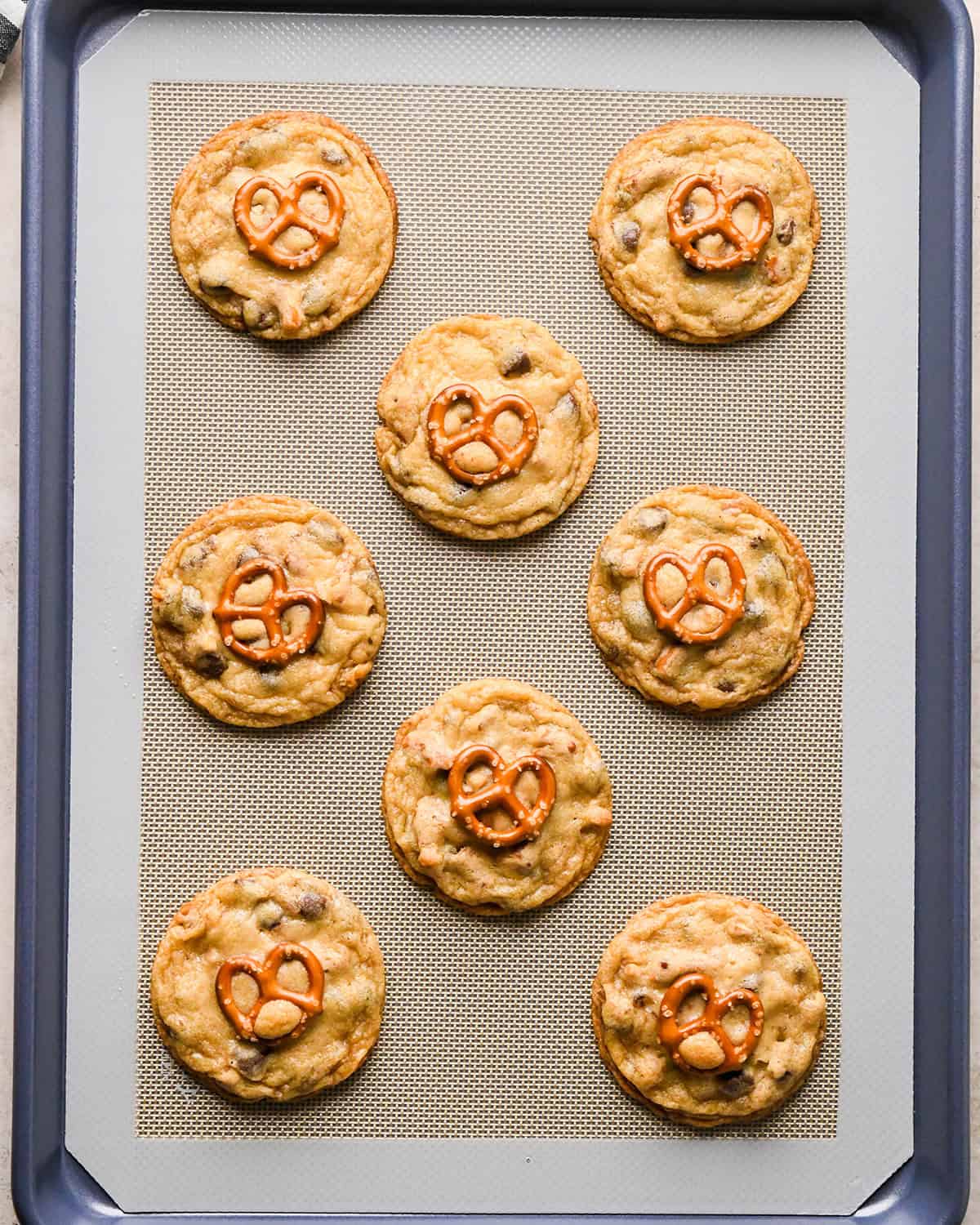 8 Chocolate Chip Pretzel Cookies on a baking sheet after baking