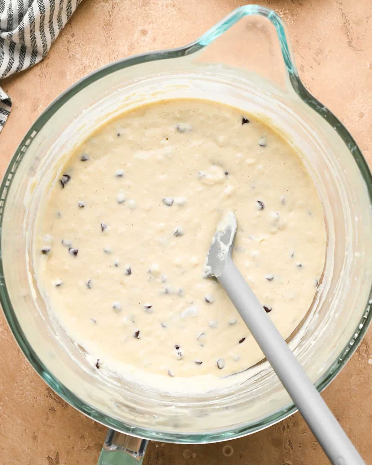 final Chocolate Chip Waffles batter in a mixing bowl with a spatula 