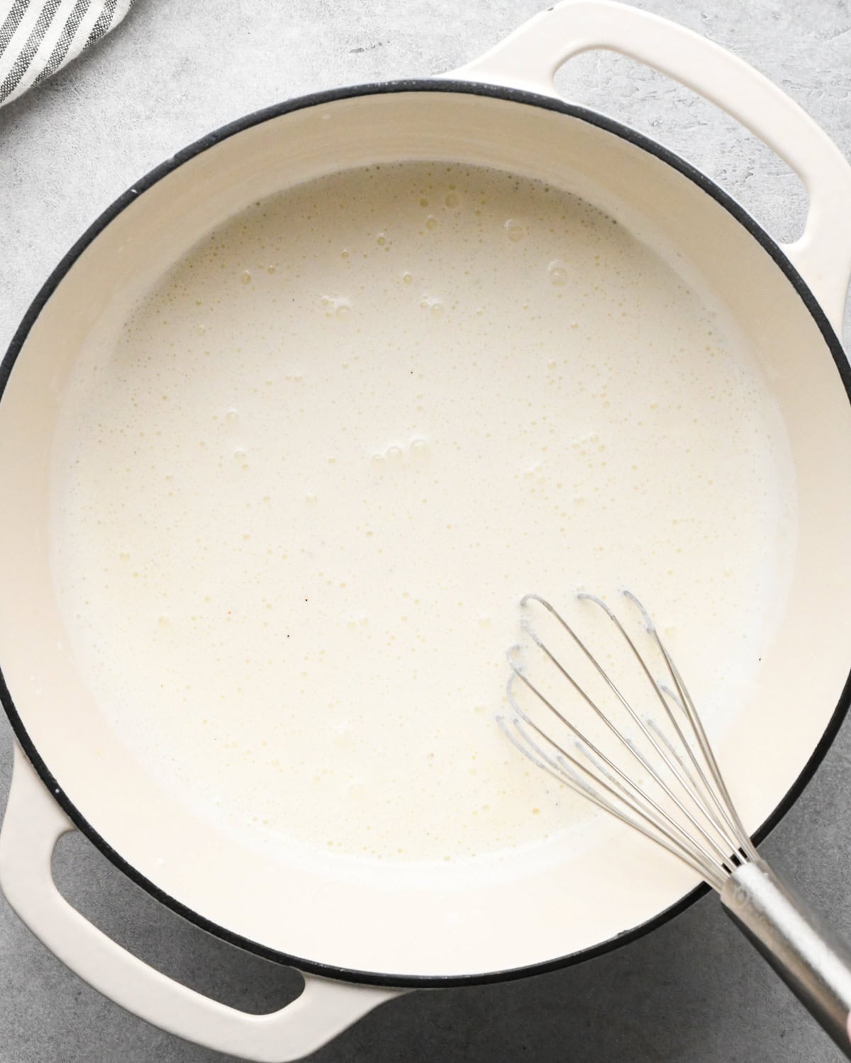cottage cheese mac and cheese sauce whisked in a white saucepan. 