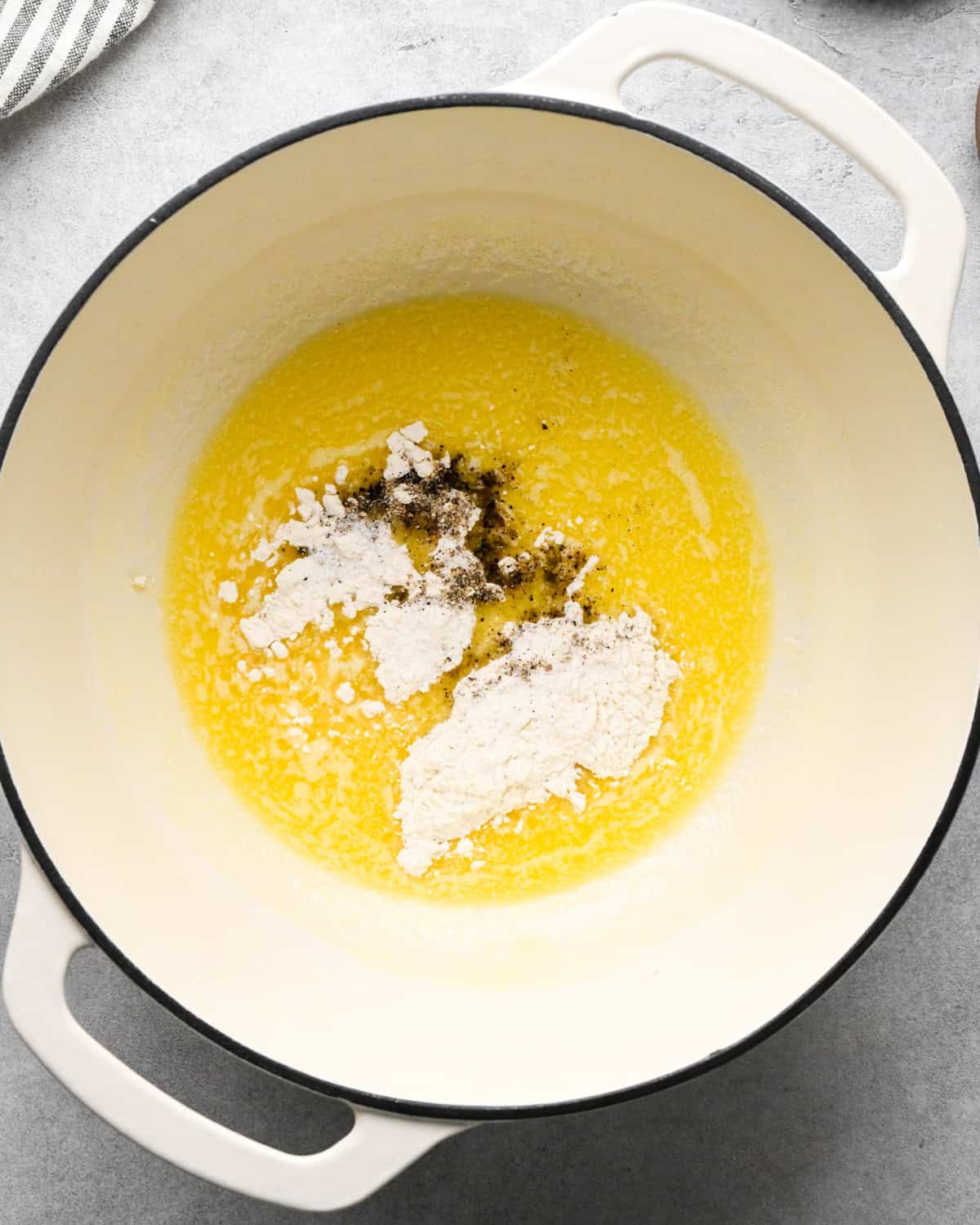 flour, salt and pepper added to the melted butter in a white saucepan making cottage cheese mac and cheese before mixing
