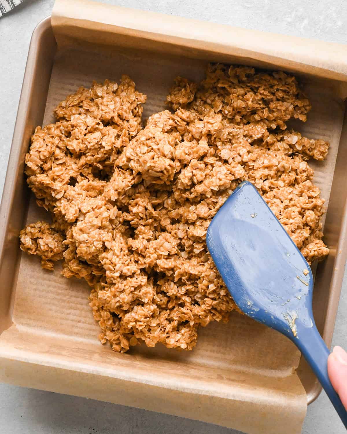 making Peanut Butter Granola Bars - pressing granola bar mixture into the prepared pan