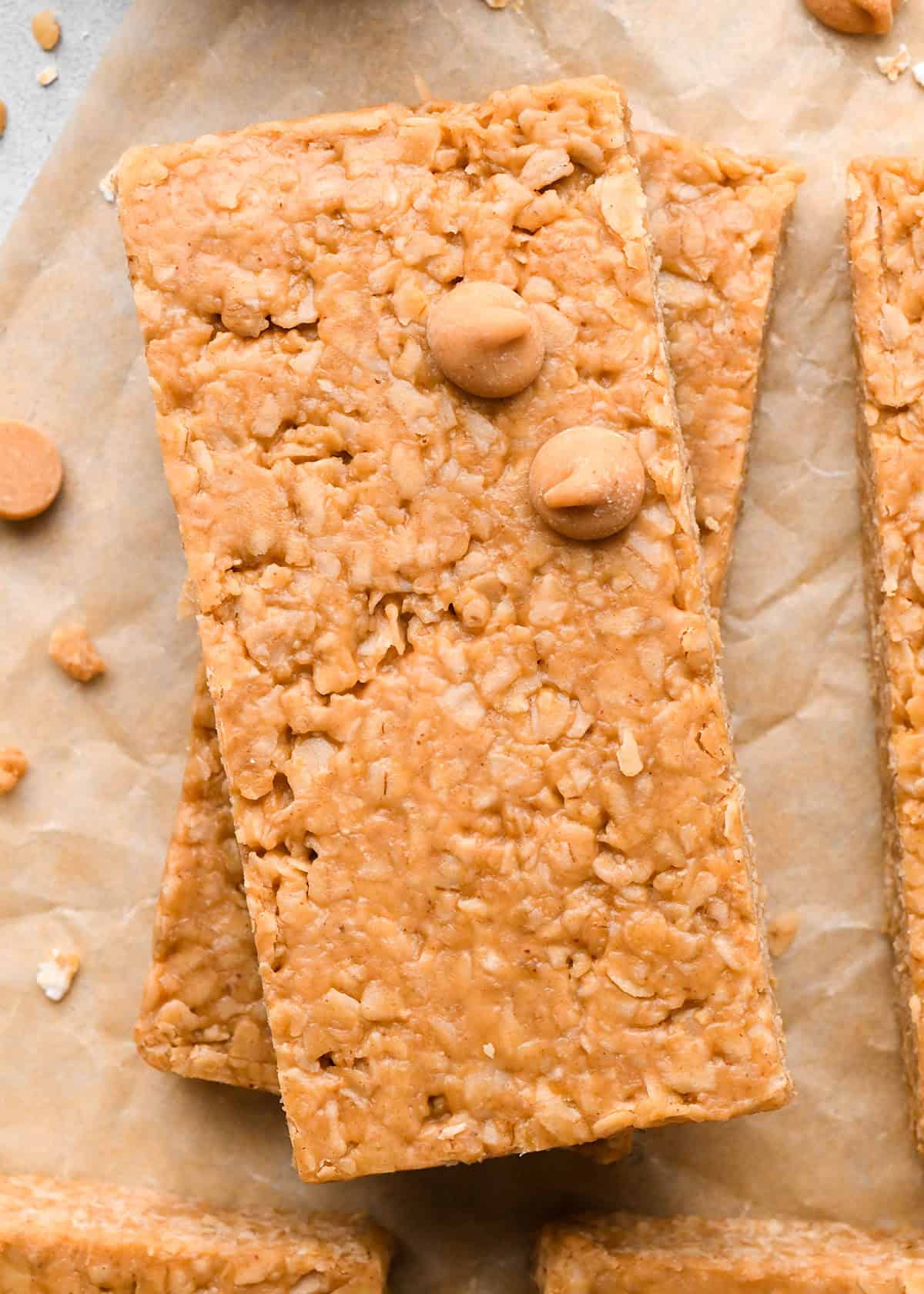 a stack of 2 peanut butter granola bars on parchment paper with peanut butter chips