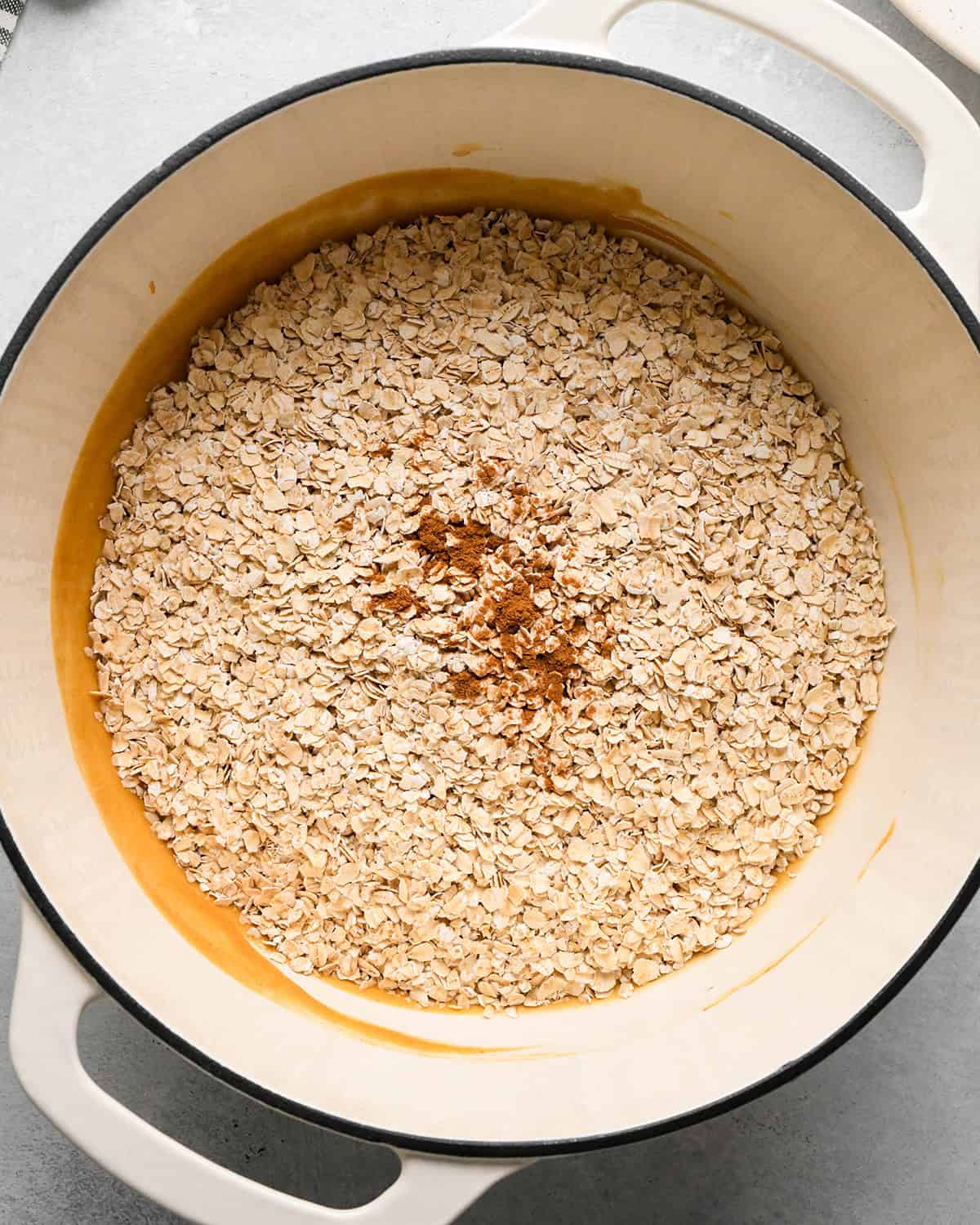 making Peanut Butter Granola Bars - oats and cinnamon added before stirring