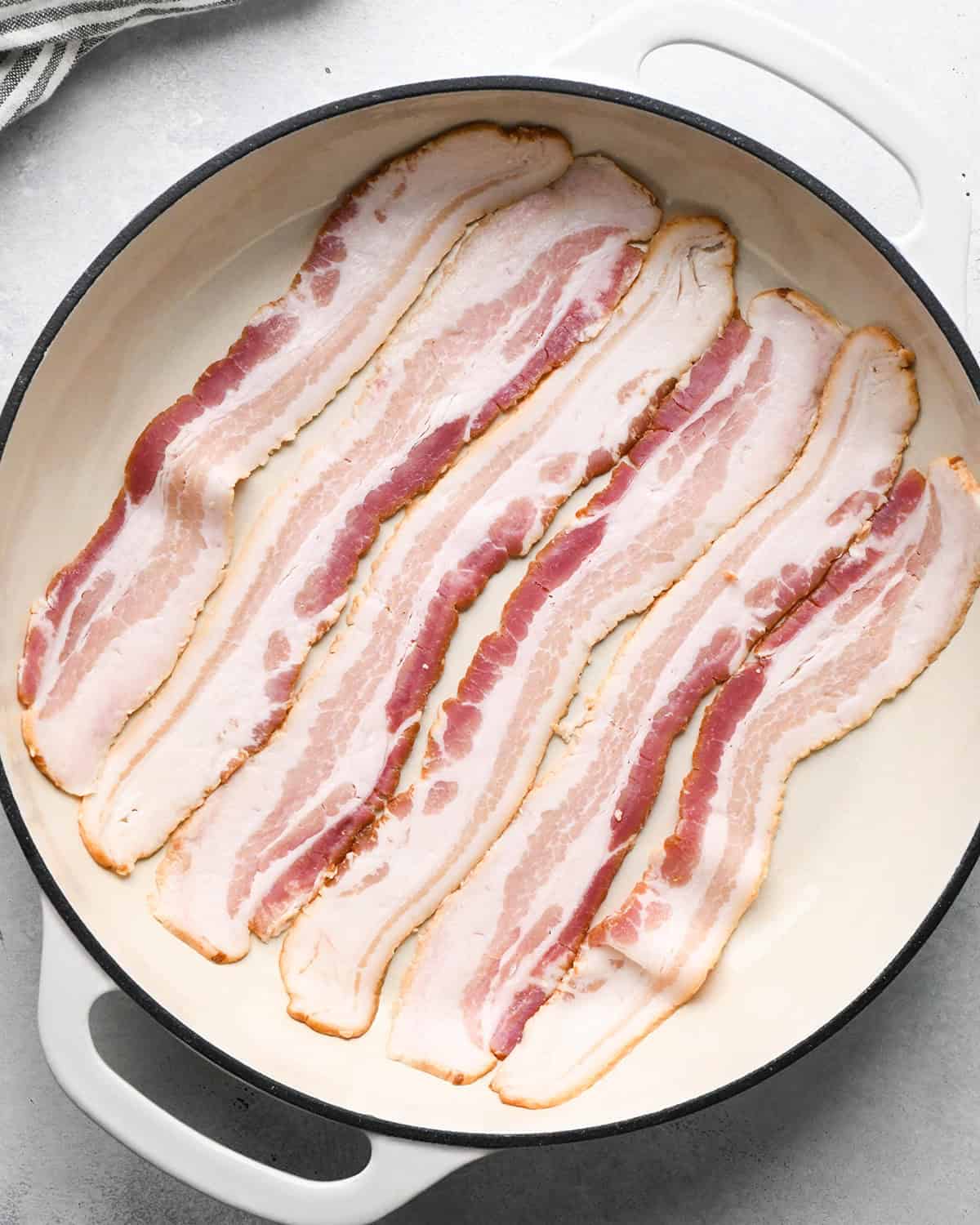uncooked bacon in a skillet