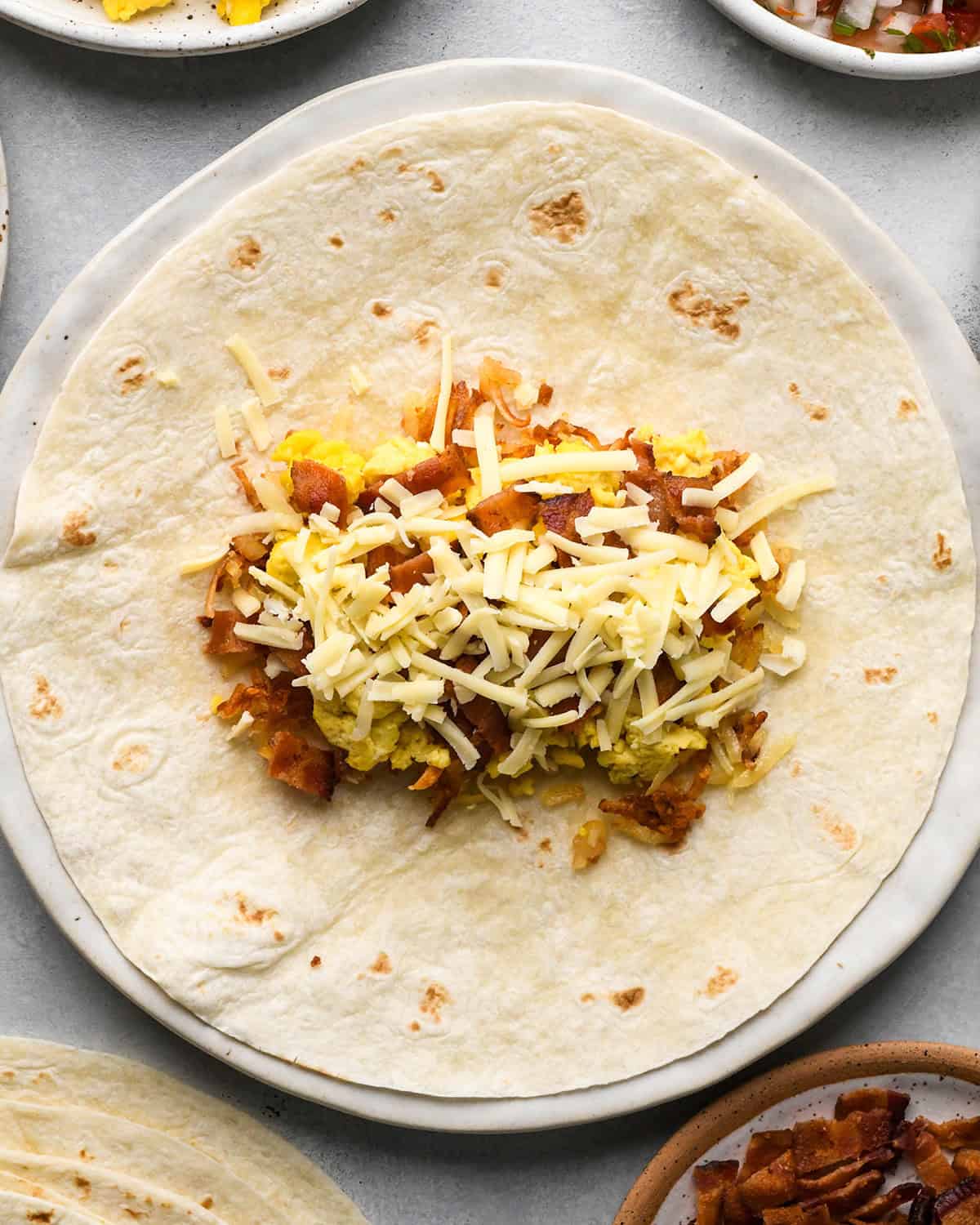 assembling a breakfast burrito - adding cheese