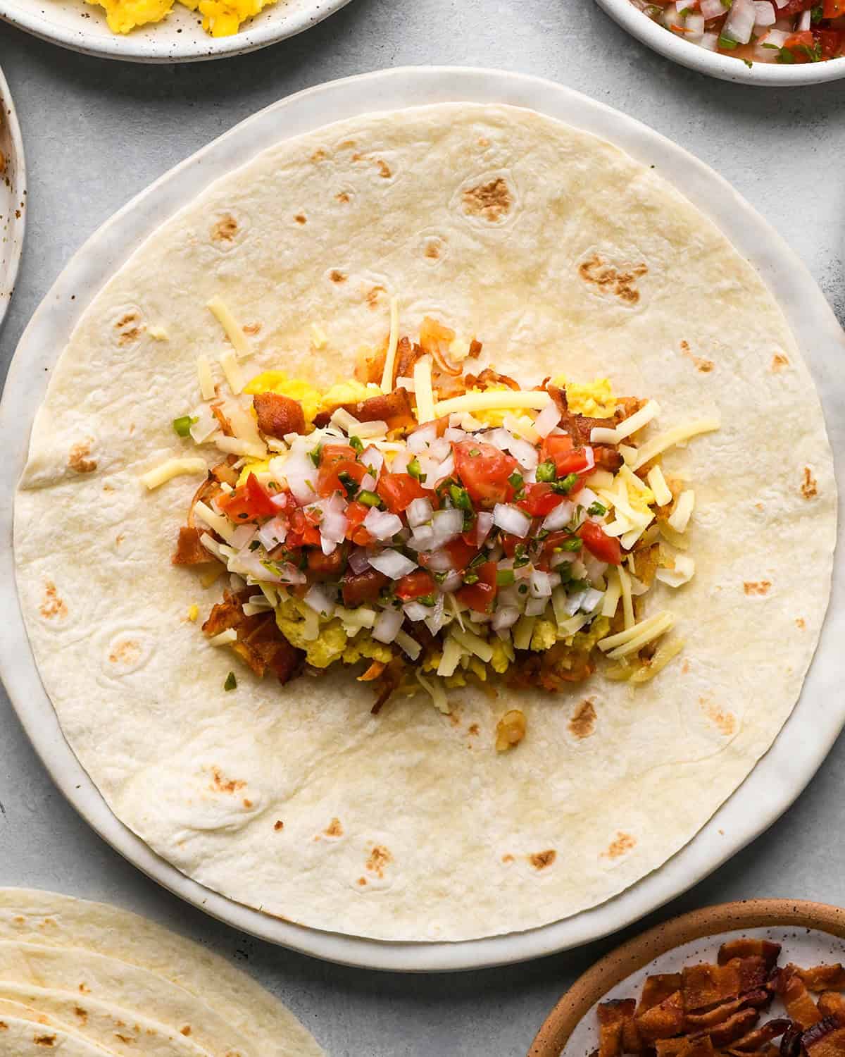 assembling a breakfast burrito - adding pico de gallo