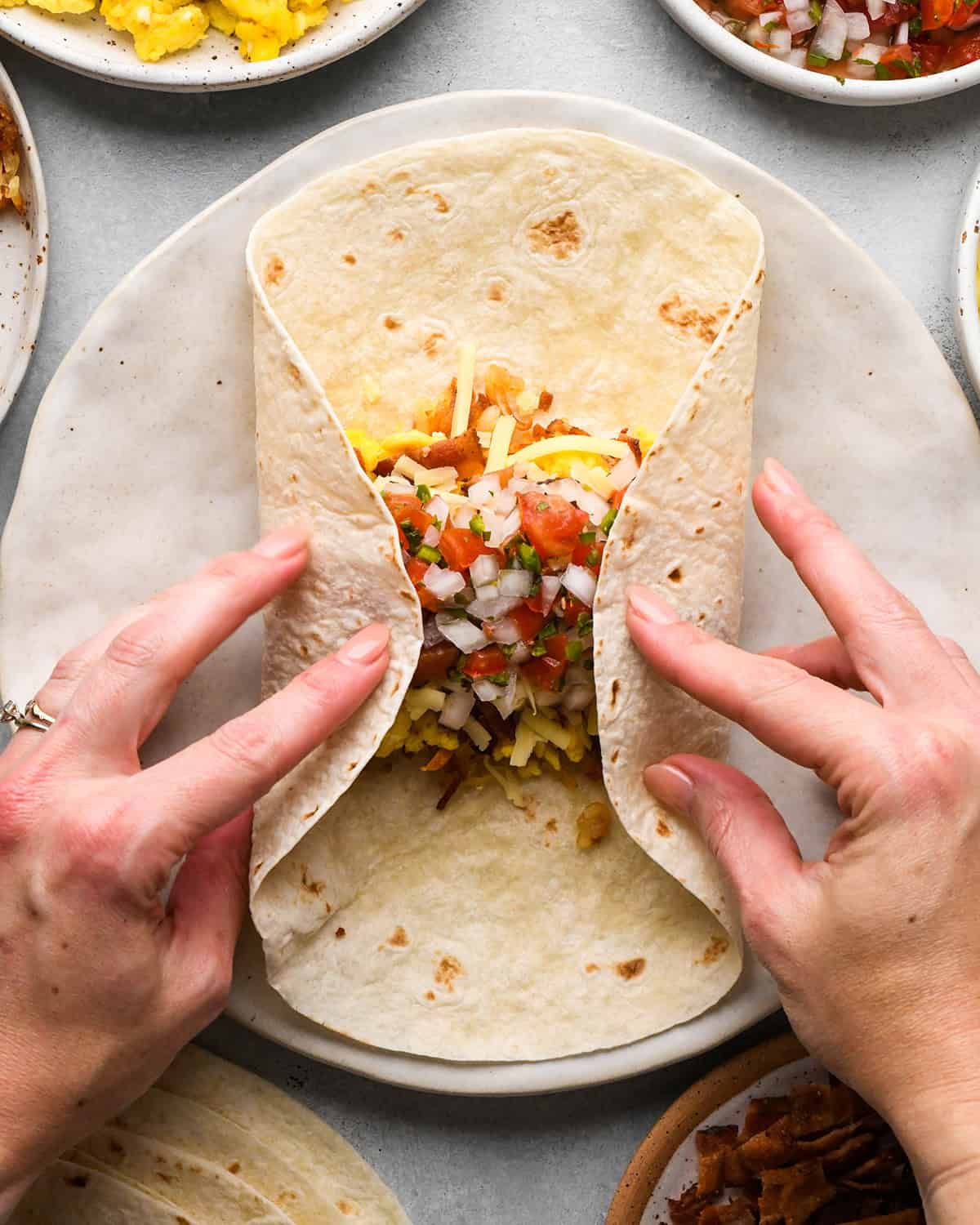 assembling a breakfast burrito - folding the sides into the middle
