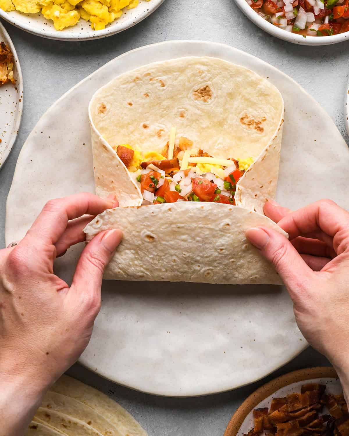 assembling a breakfast burrito - folding the long side over the filling