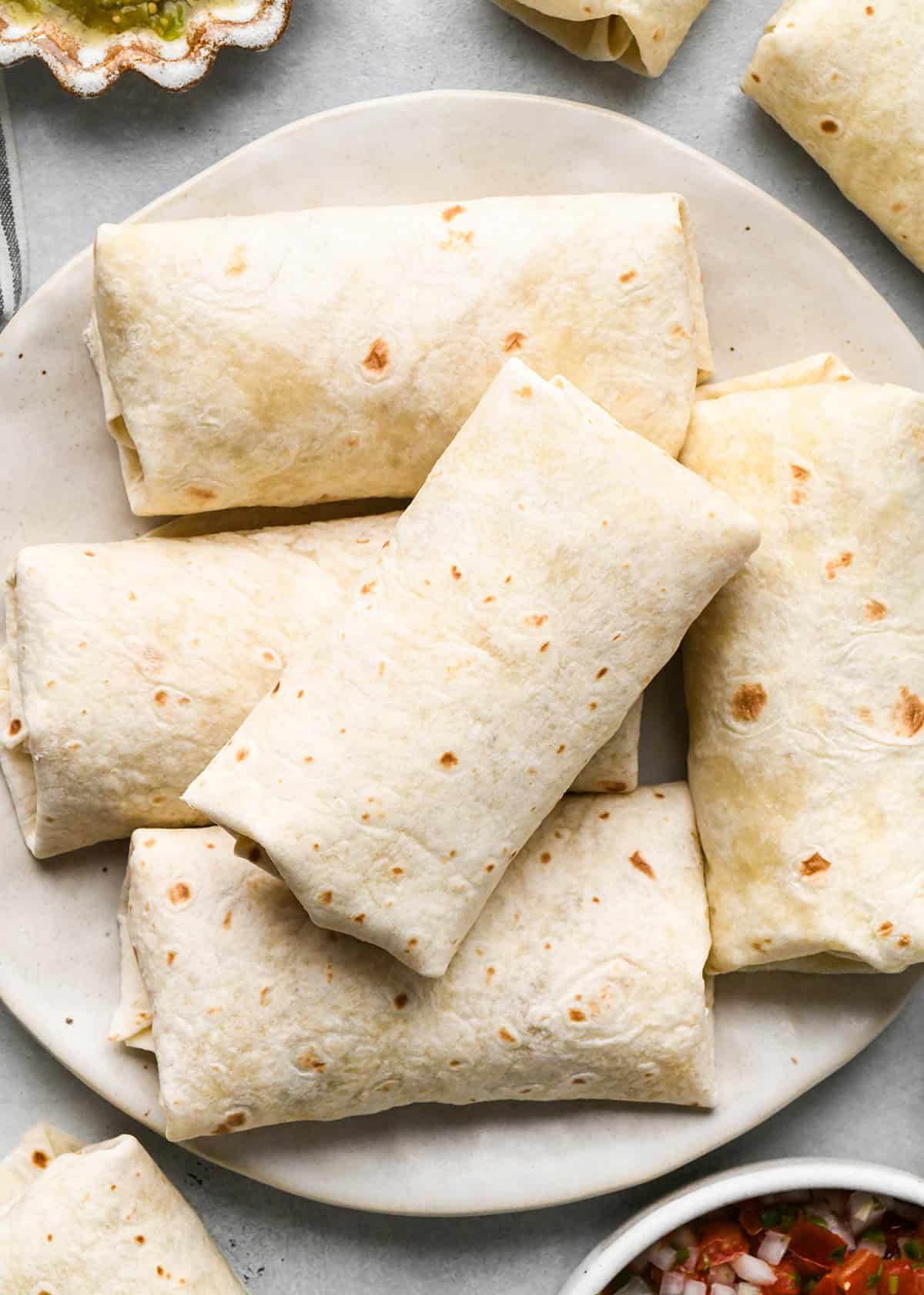 5 assembled breakfast burritos on a plate