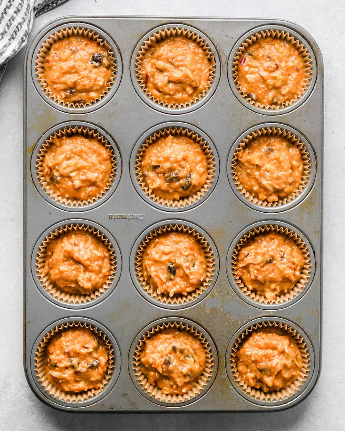 12 morning glory  muffins in a muffin tin before baking