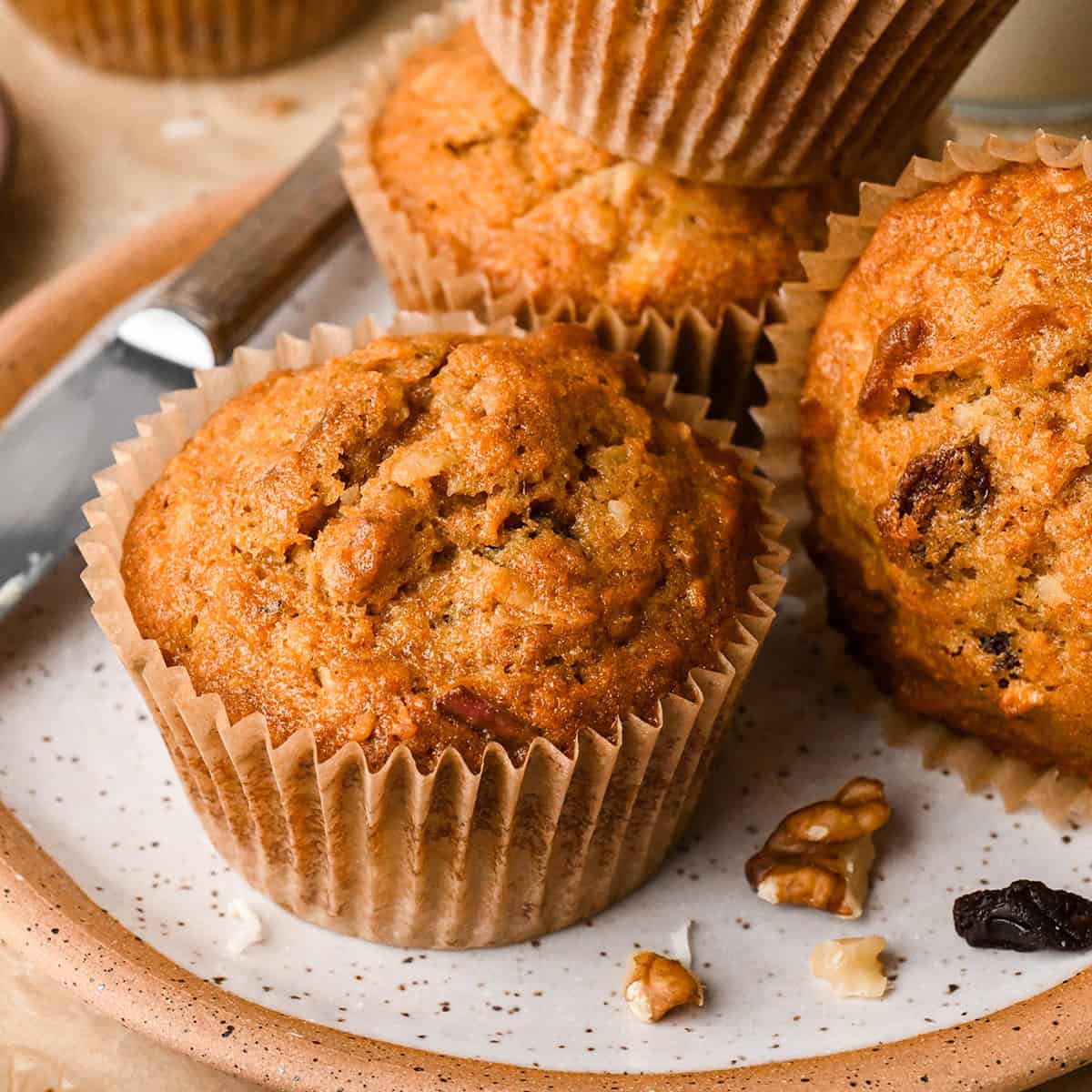 4 Morning Glory Muffins on a plate with walnuts and raisins 