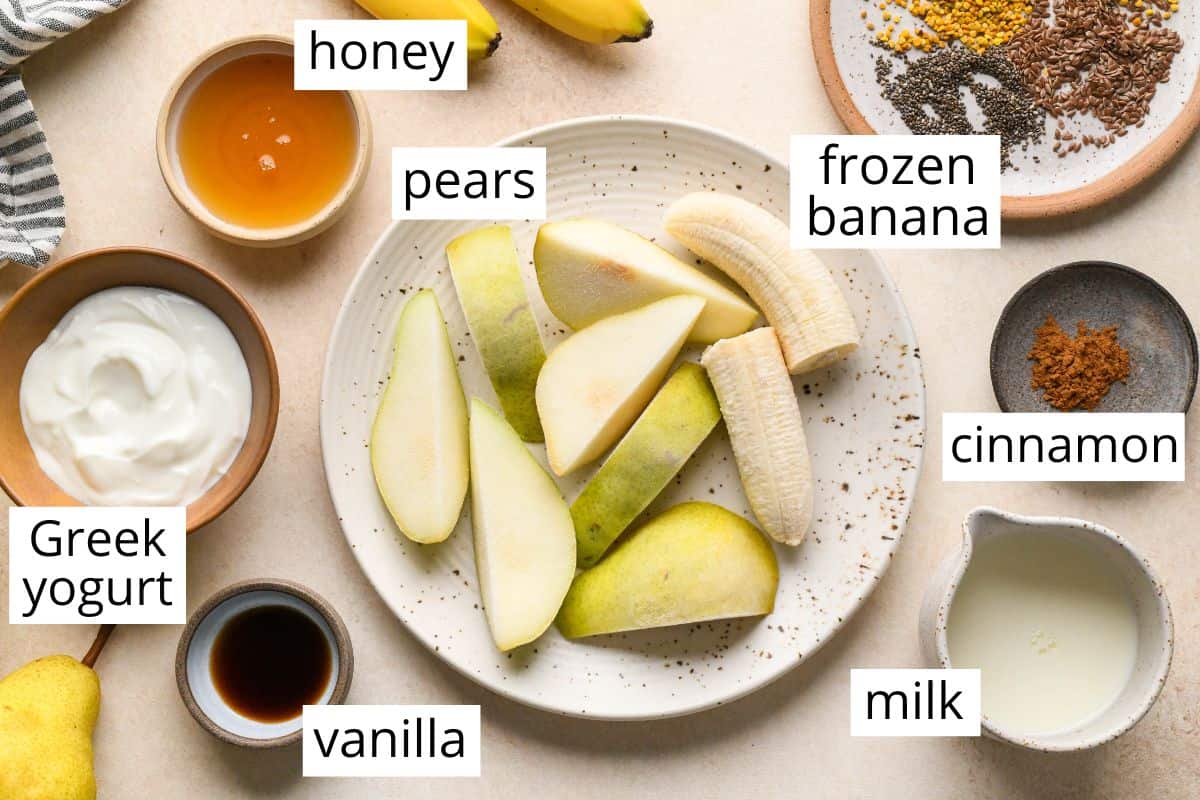 overhead photo of the labeled ingredients in this Pear Smoothie recipe like pears, banana, vanilla, greek yogurt, and milk
