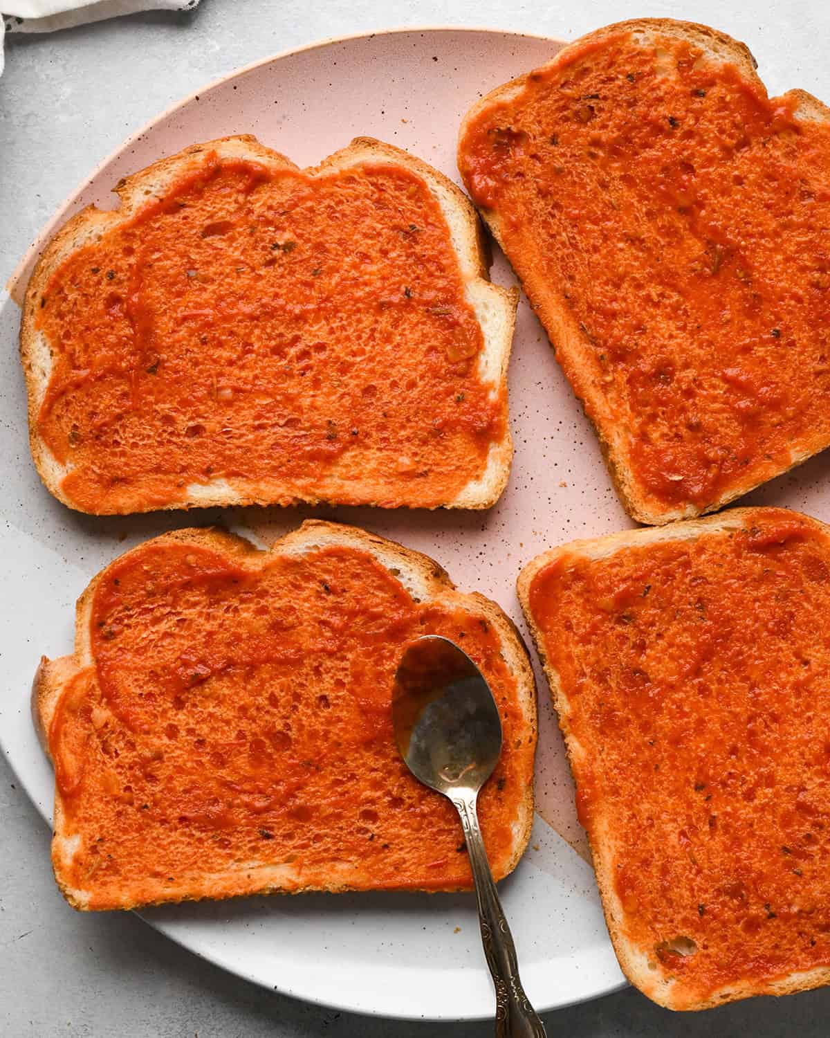 making Pizza Grilled Cheese - pizza sauce spread on 4 pieces of bread