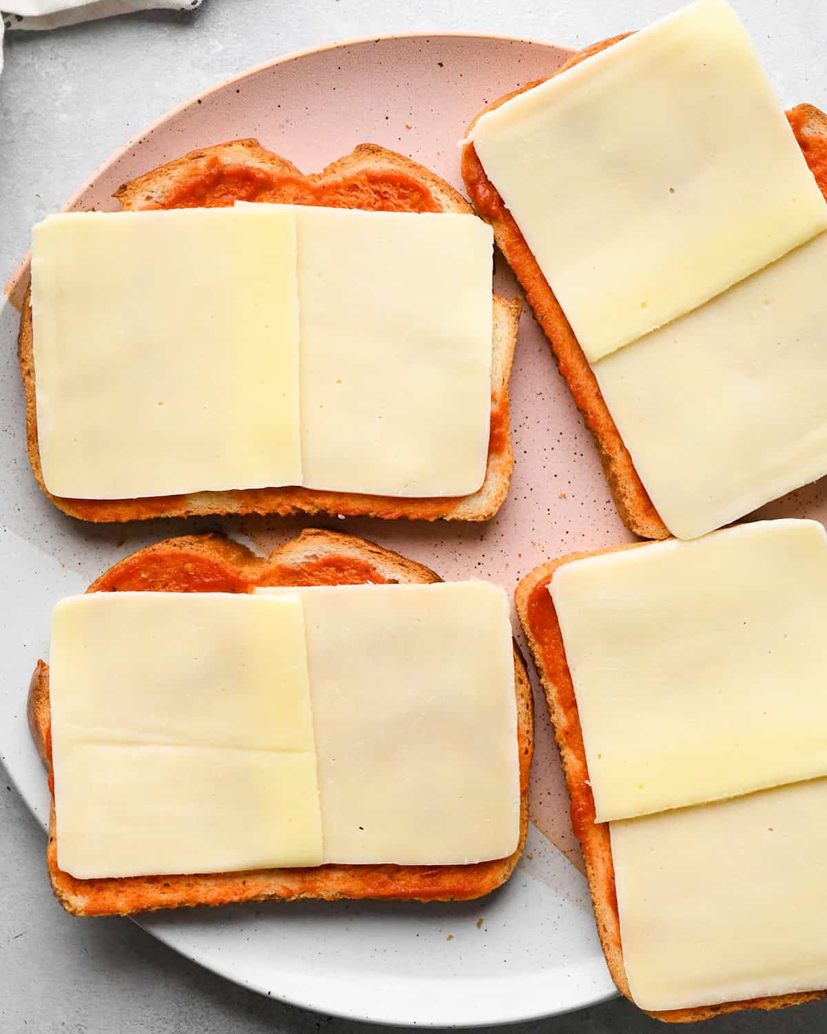 making Pizza Grilled Cheese - mozzarella cheese placed on 4 pieces of bread