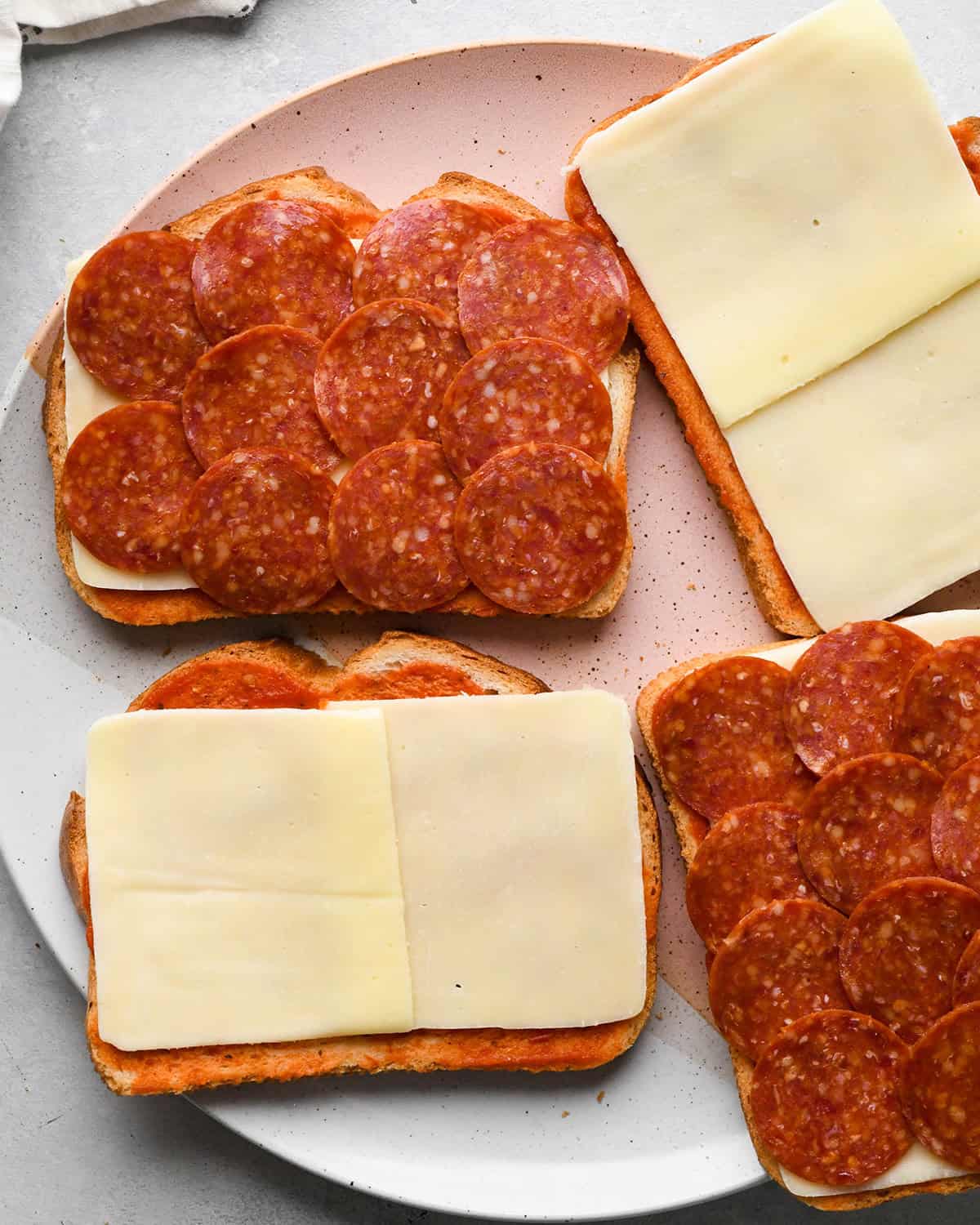 making Pizza Grilled Cheese - pepperoni on two pieces of bread 