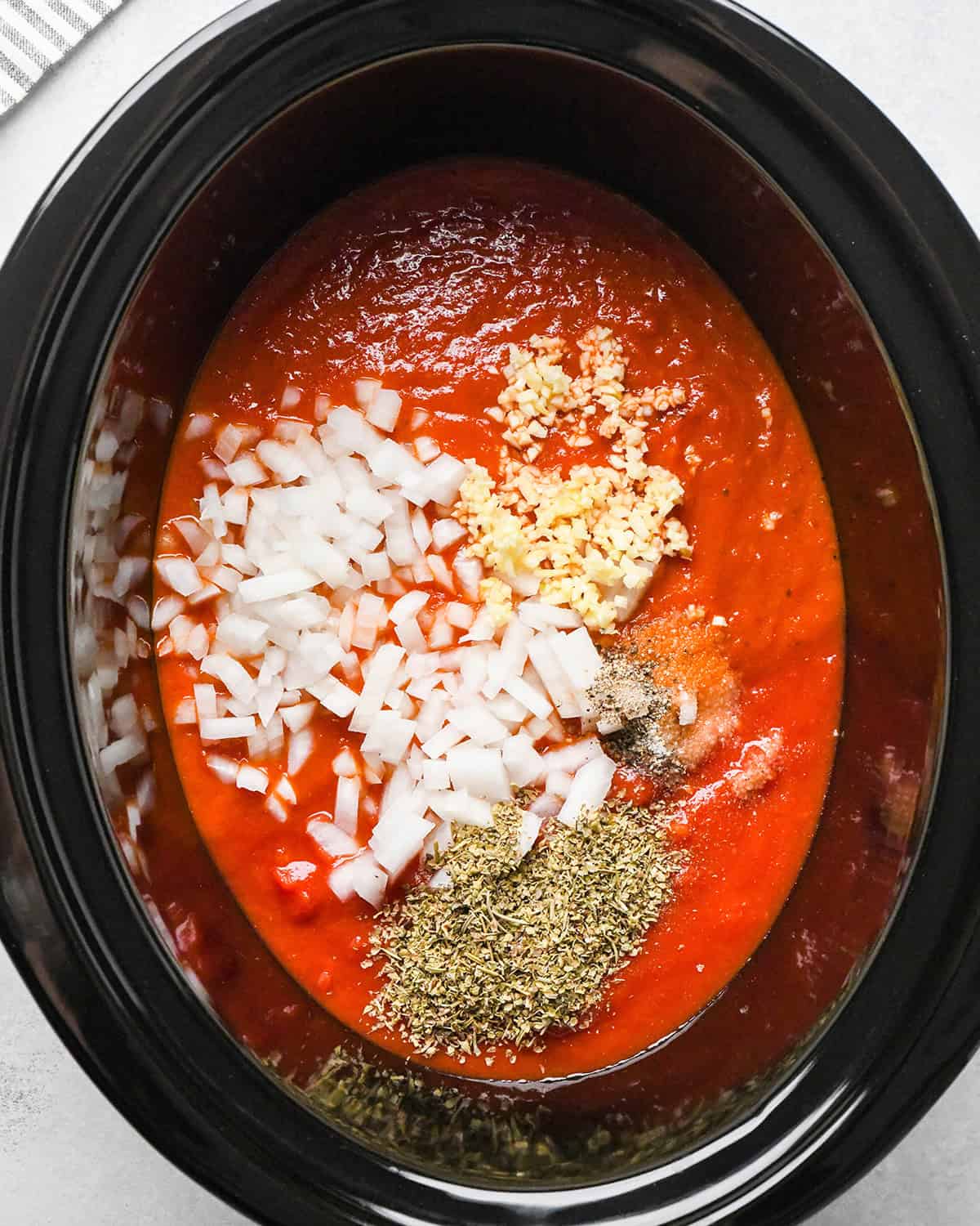 making slow cooker meatballs - sauce ingredients in a crock pot before mixing