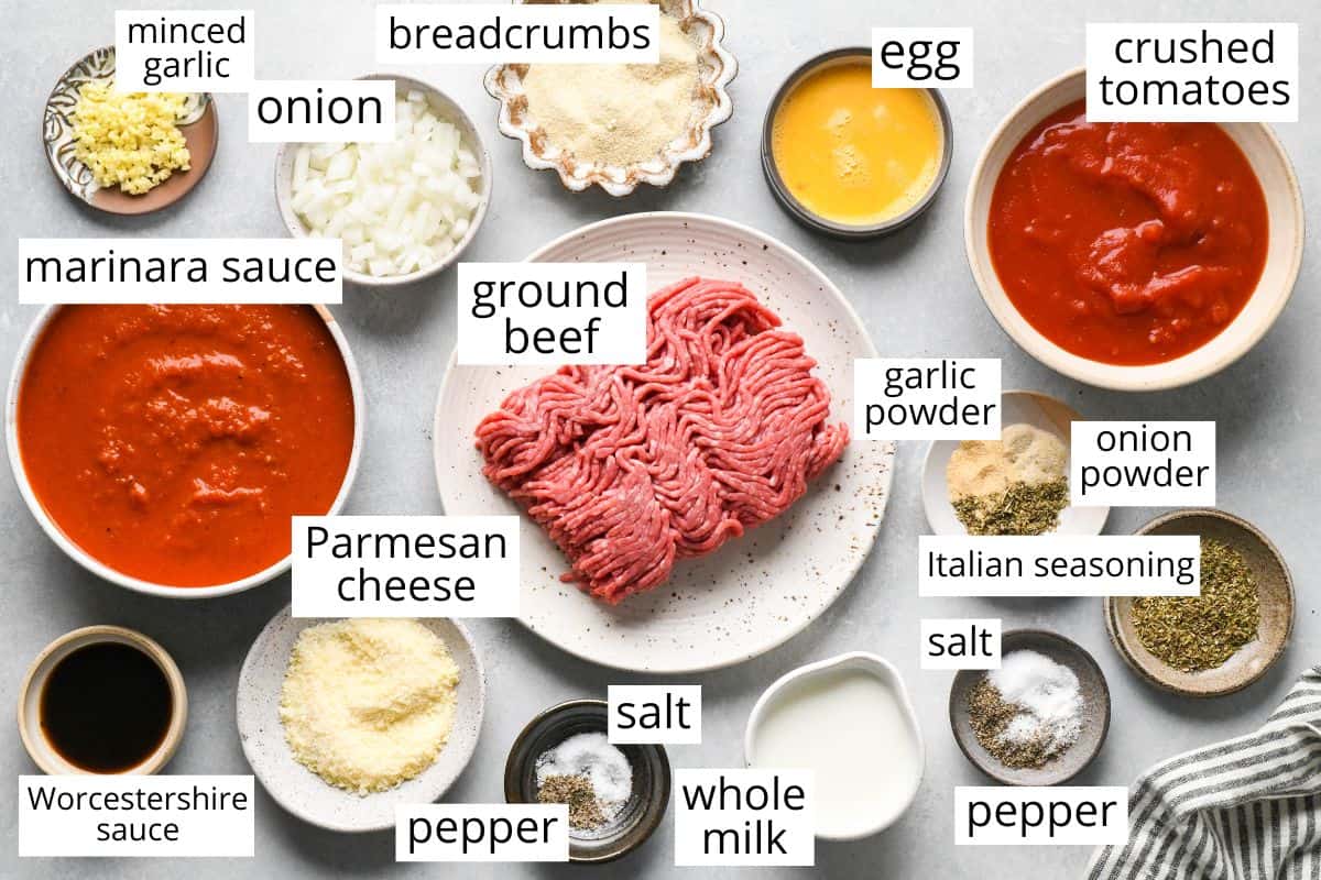 overhead photo of the labeled ingredients in this Slow Cooker Meatballs recipe like ground beef, marinara sauce, parmesan cheese, milk, egg, tomatoes and spices