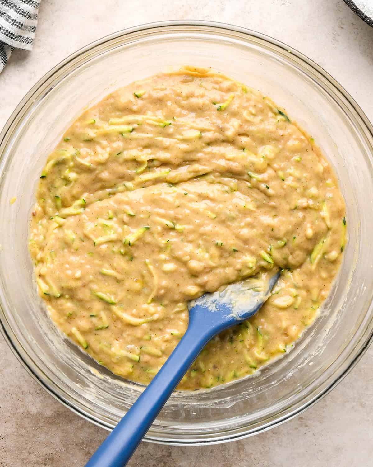 making zucchini banana bread - final batter in a bowl with a spatula