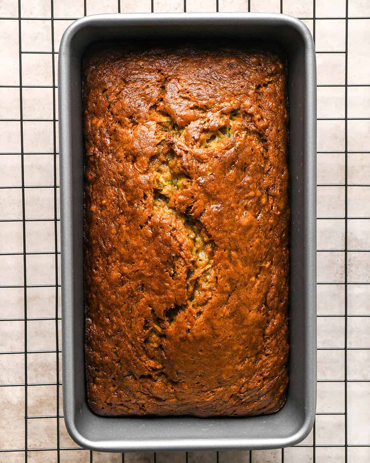 baked Zucchini Banana Bread in a loaf pan on a wire cooling rack