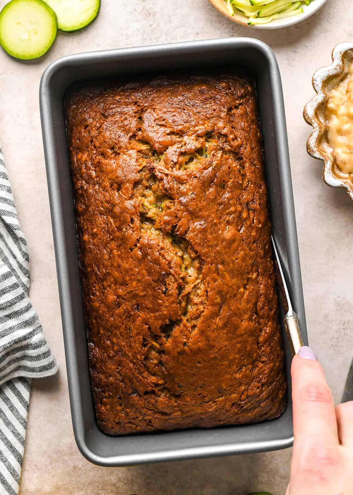 Zucchini Banana Bread being removed from a loaf pan