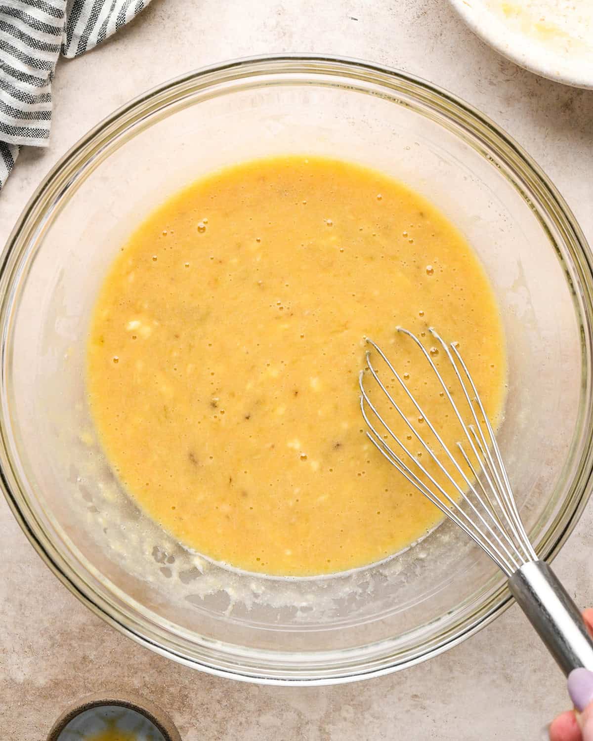 making zucchini banana bread - wet ingredients whisked in a glass bowl