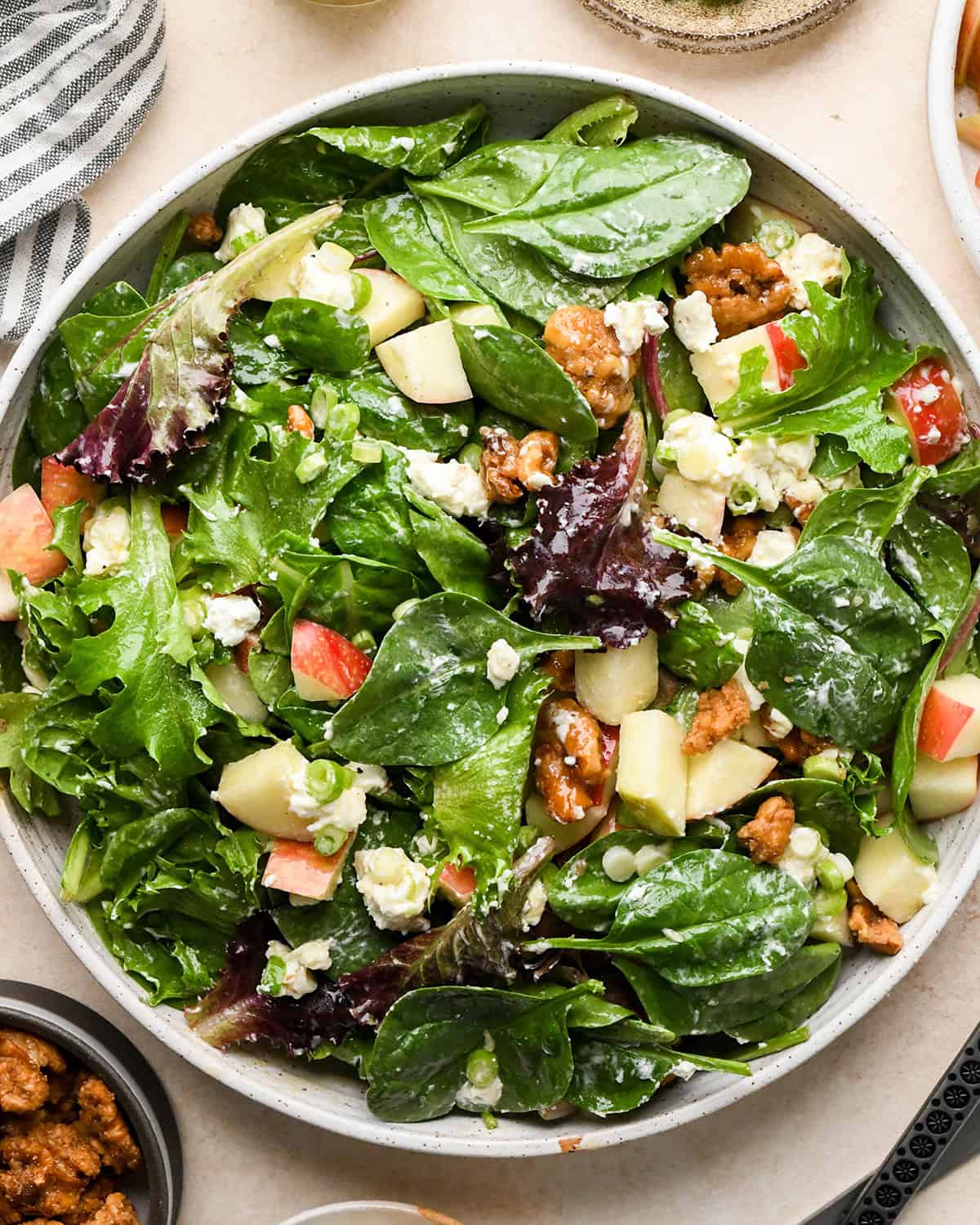 apple salad in a bowl after being tossed with dressing