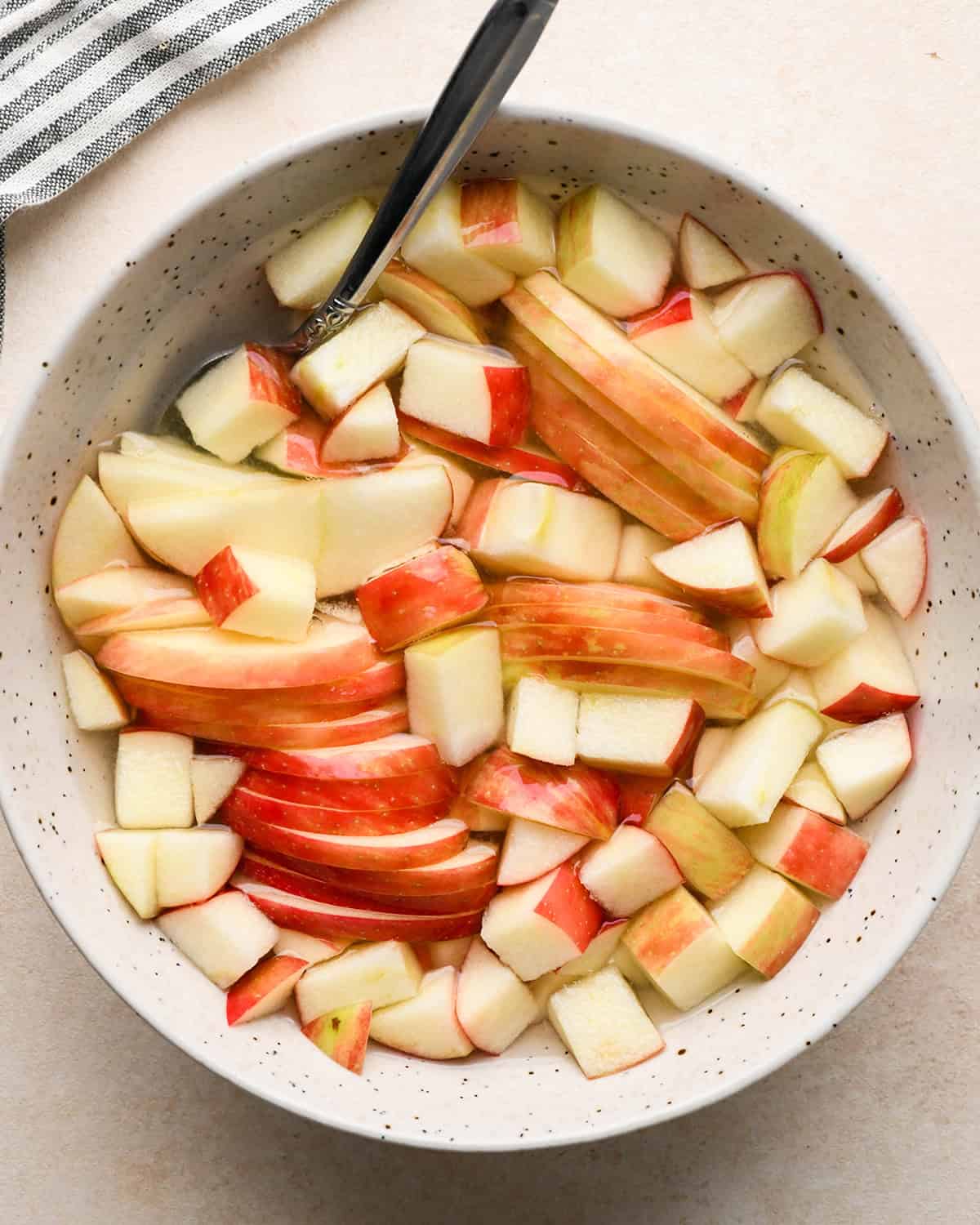 making Apple Salad - apples put into a bowl of lemon water