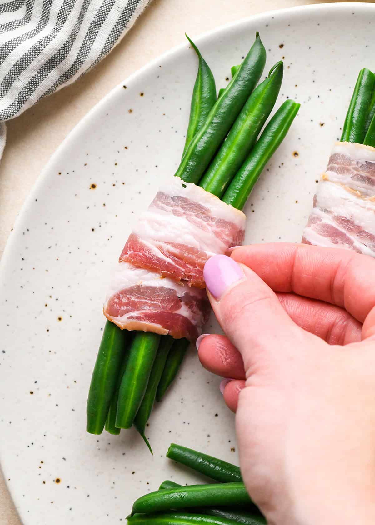 assembling bacon wrapped green beans, bacon wrapped around the green beans