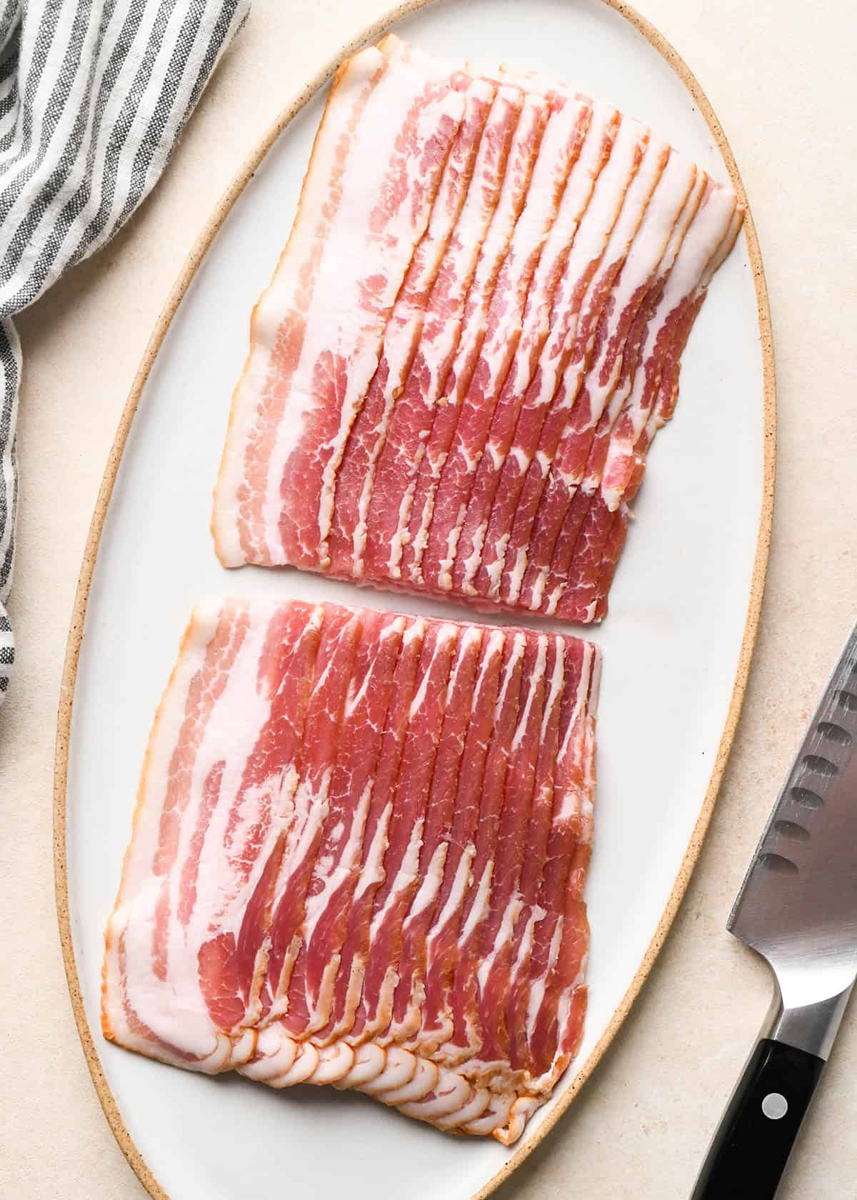12 slices of bacon stuck together and cut in half on a plate