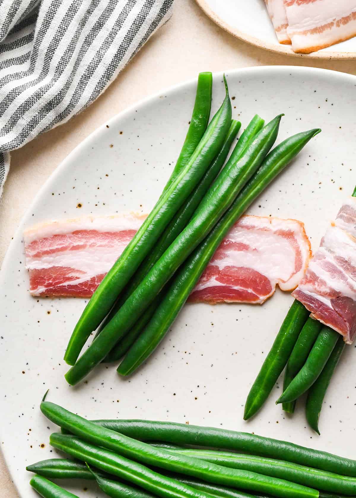 assembling Bacon Wrapped Green Beans - 6 green beans on top of a half piece of bacon