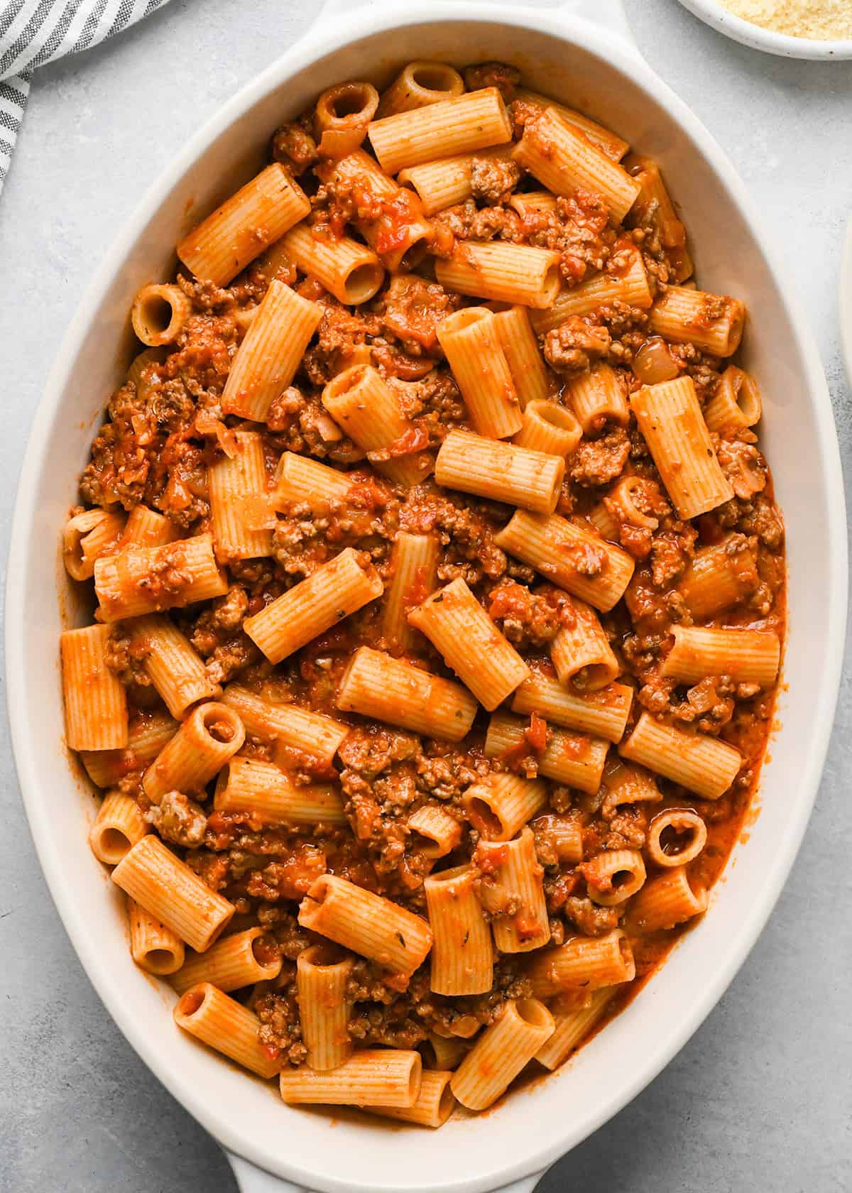 Baked Mostaccioli mixture spread into a white baking dish 