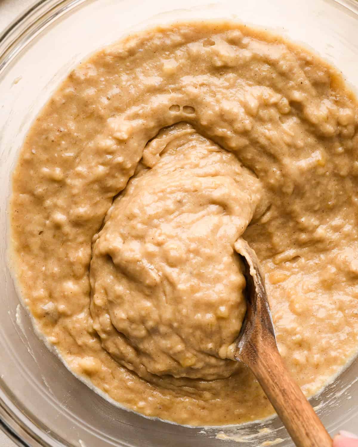 final banana crumb muffins batter in a bowl with a wooden spoon