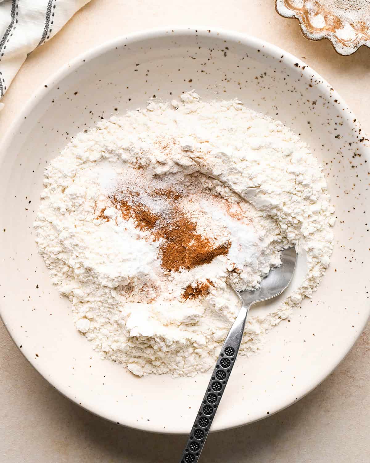 making Banana Crumb Muffins - dry ingredients in a bowl with a spoon before mixing