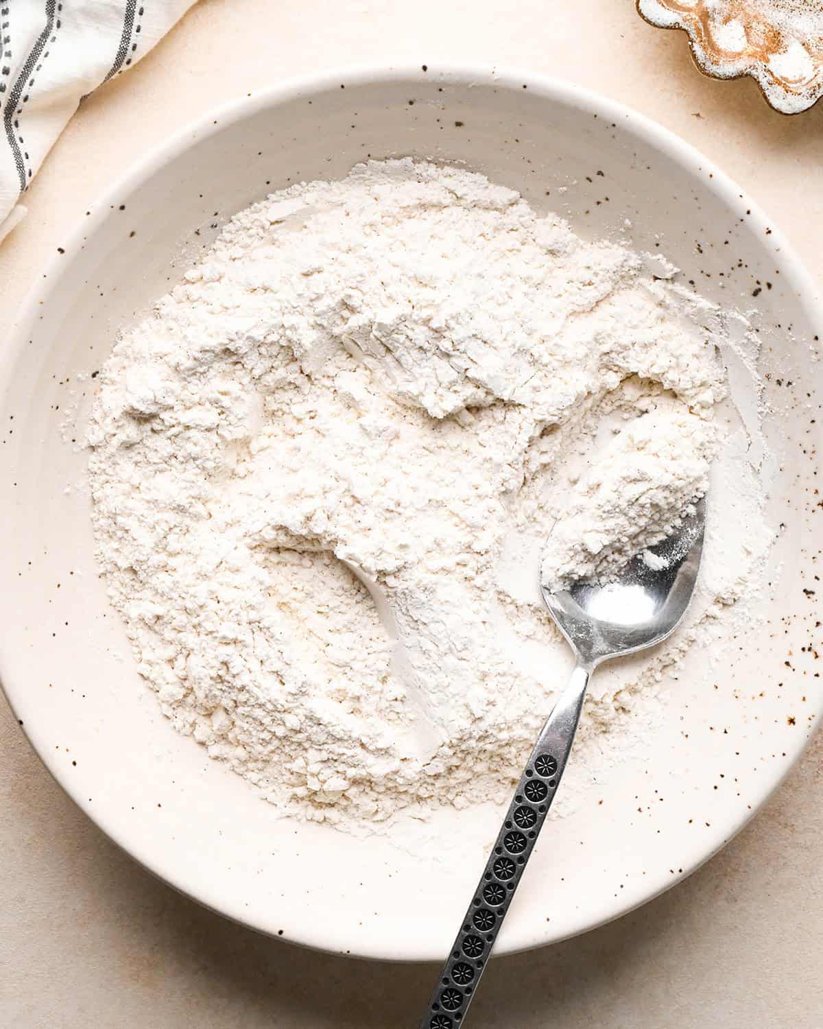 making Banana Crumb Muffins - dry ingredients in a bowl with a spoon after mixing