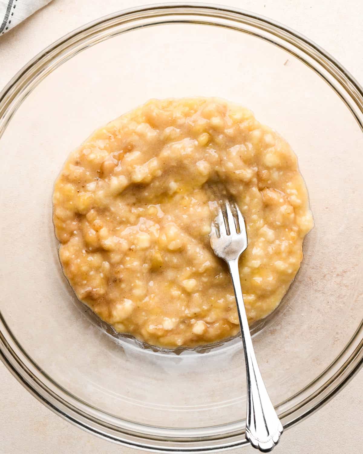 mashed banana in a bowl with a fork