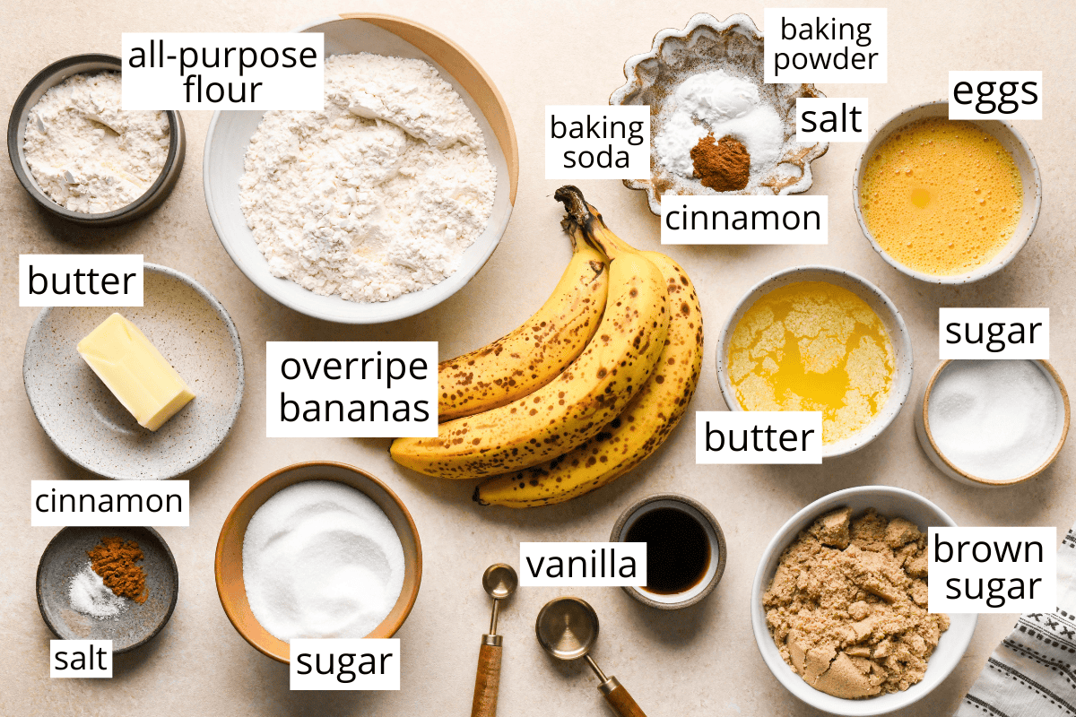 overhead photo of the labeled ingredients in this Banana Crumb Muffins recipe like flour, bananas, butter, brown sugar, white sugar, cinnamon, eggs, and more all in bowls