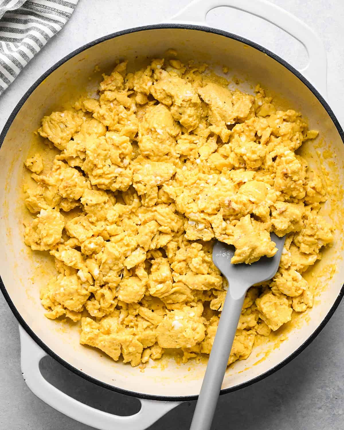 making breakfast tacos - scrambled eggs in a pan with a spatula