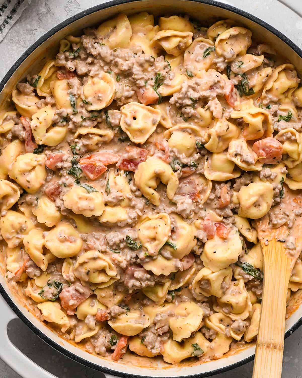 Ground Beef Tortellini in a pan with a wooden spatula