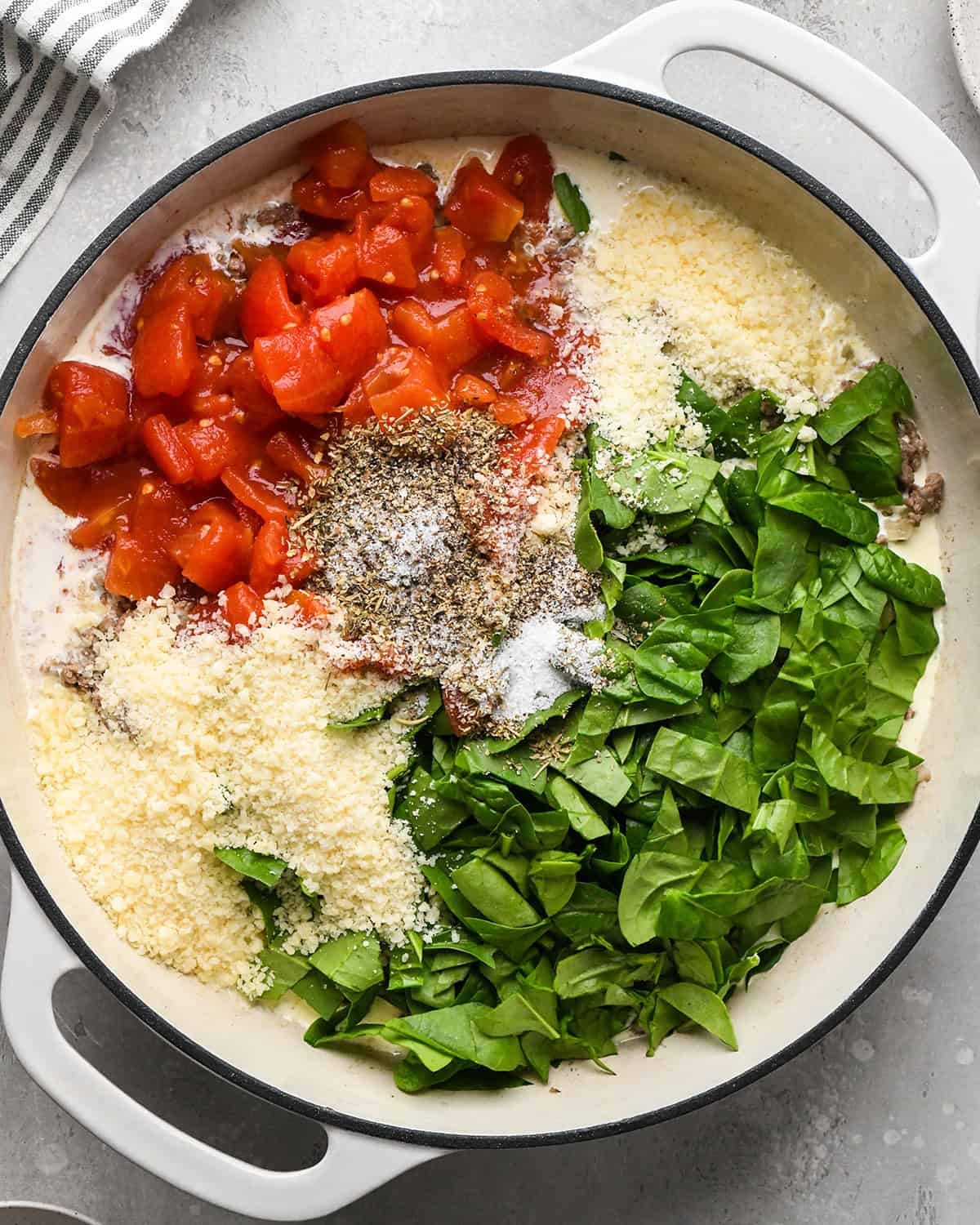making Ground Beef Tortellini - cream, tomatoes, parmesan, spices and spinach added before mixing