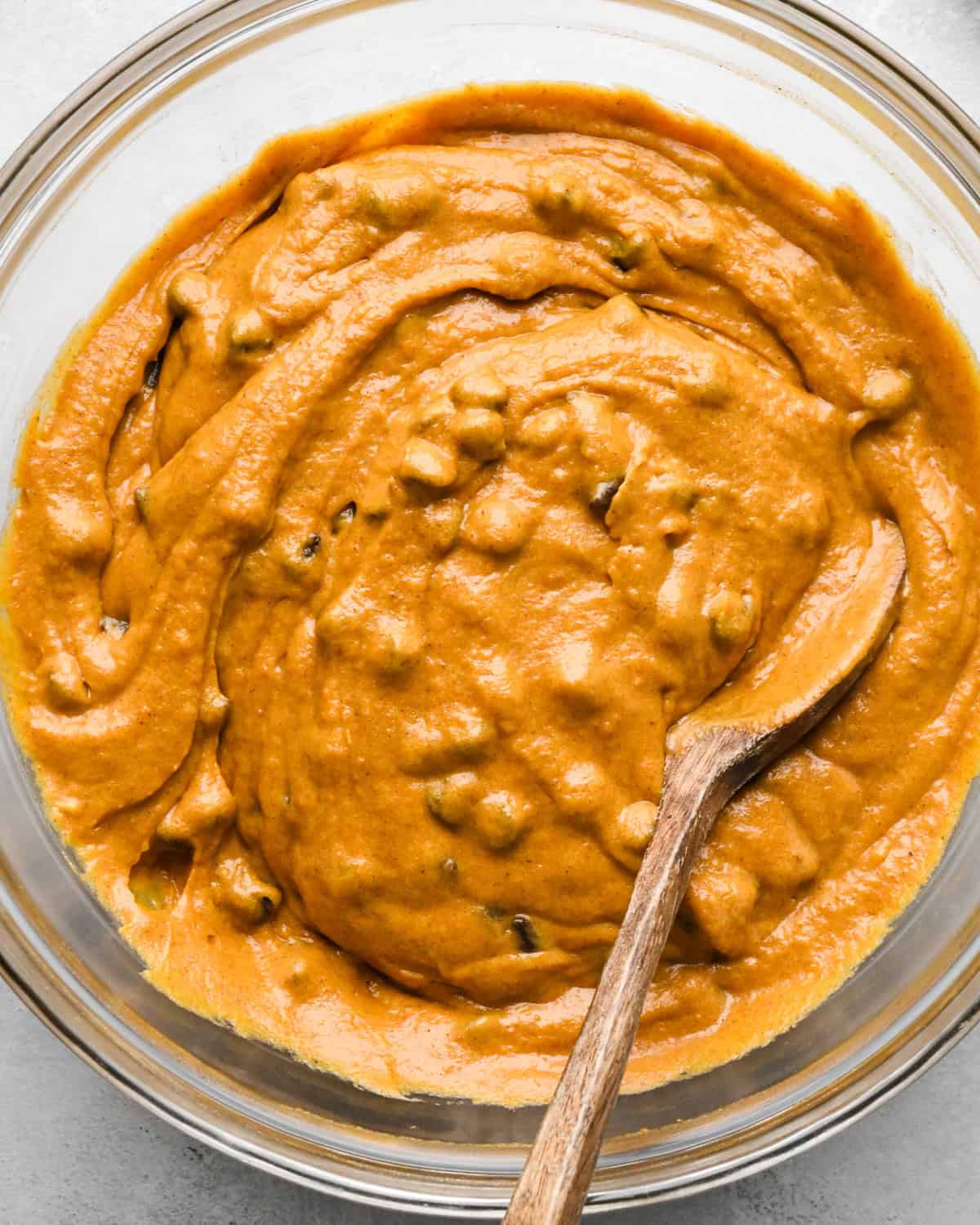 final Pumpkin Chocolate Chip Bread batter in a bowl with a wooden spoon
