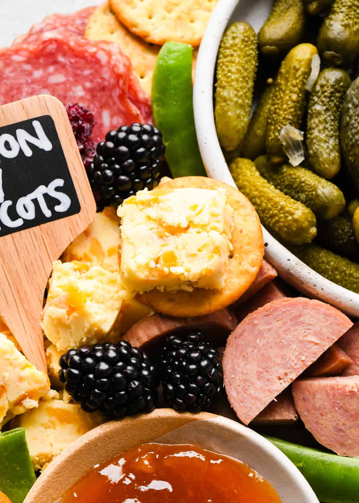 up close photo of a cracker with cheese on a charcuterie board