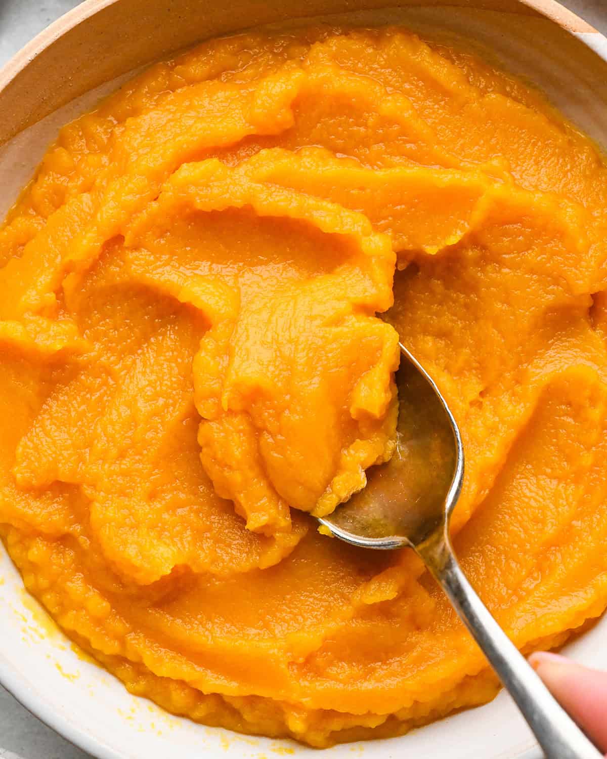 up close photo of homemade pumpkin puree in a bowl with a spoon